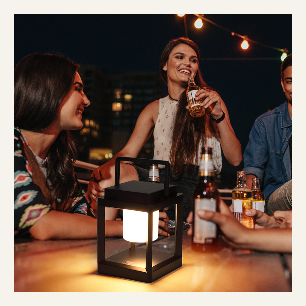 Black portable camping lantern on an outdoor table