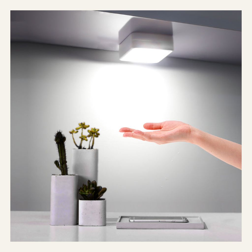 White motion-sensor cabinet light installed under a shelf
