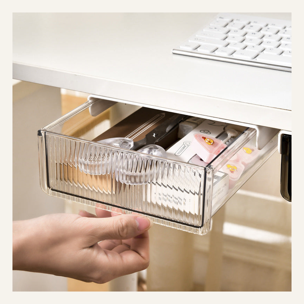 Transparent under-desk drawer holding office supplies