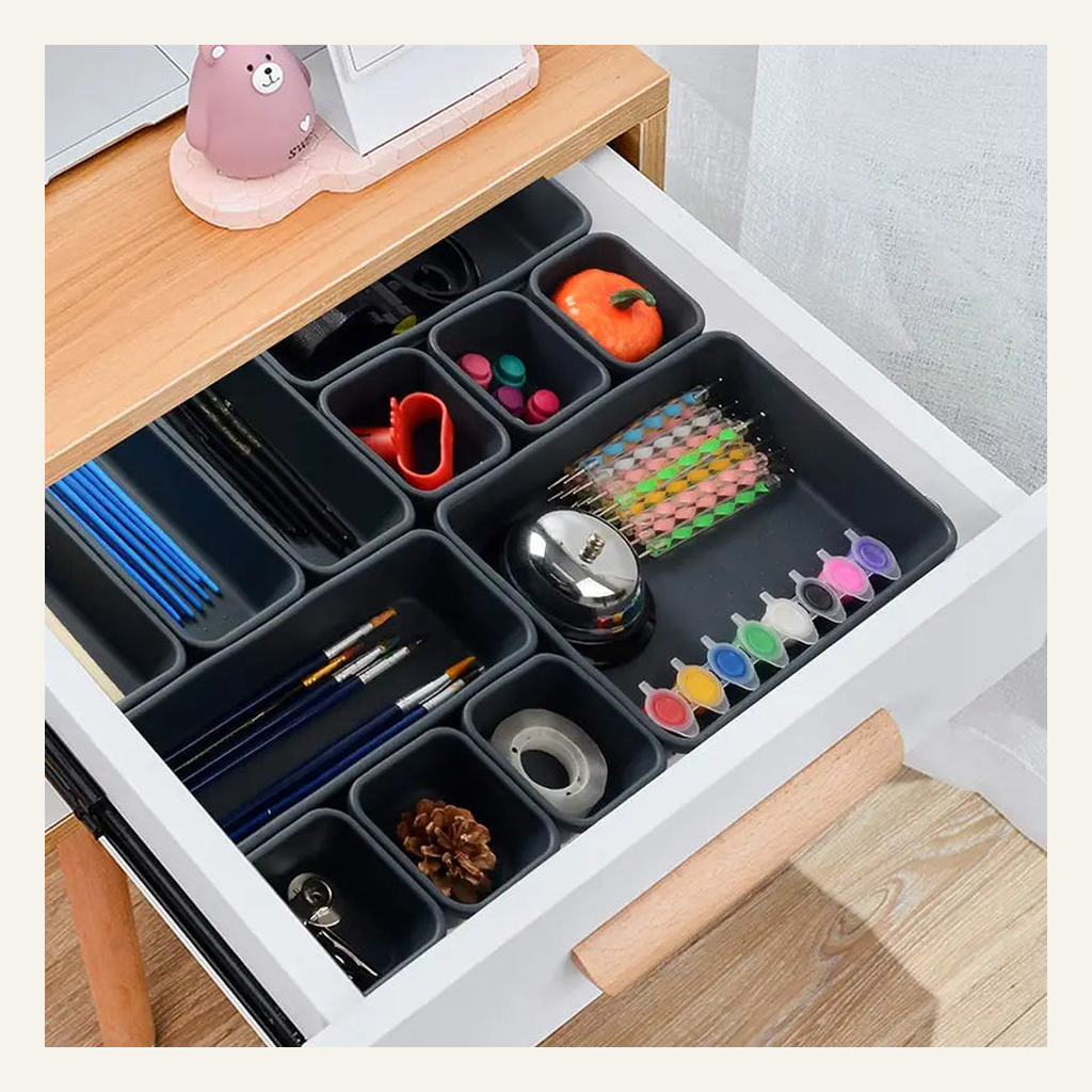 Gray interlocking drawer organizer bins holding desk supplies