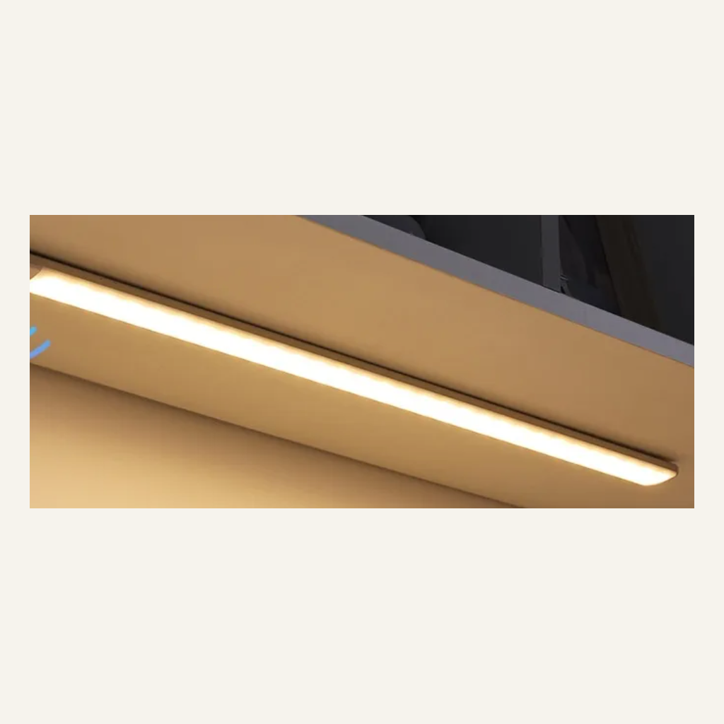 White motion-sensor cabinet light installed under a shelf