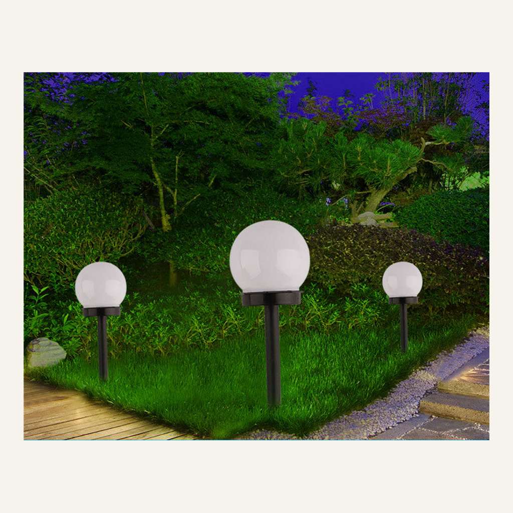 White solar globe garden lights illuminated along a path