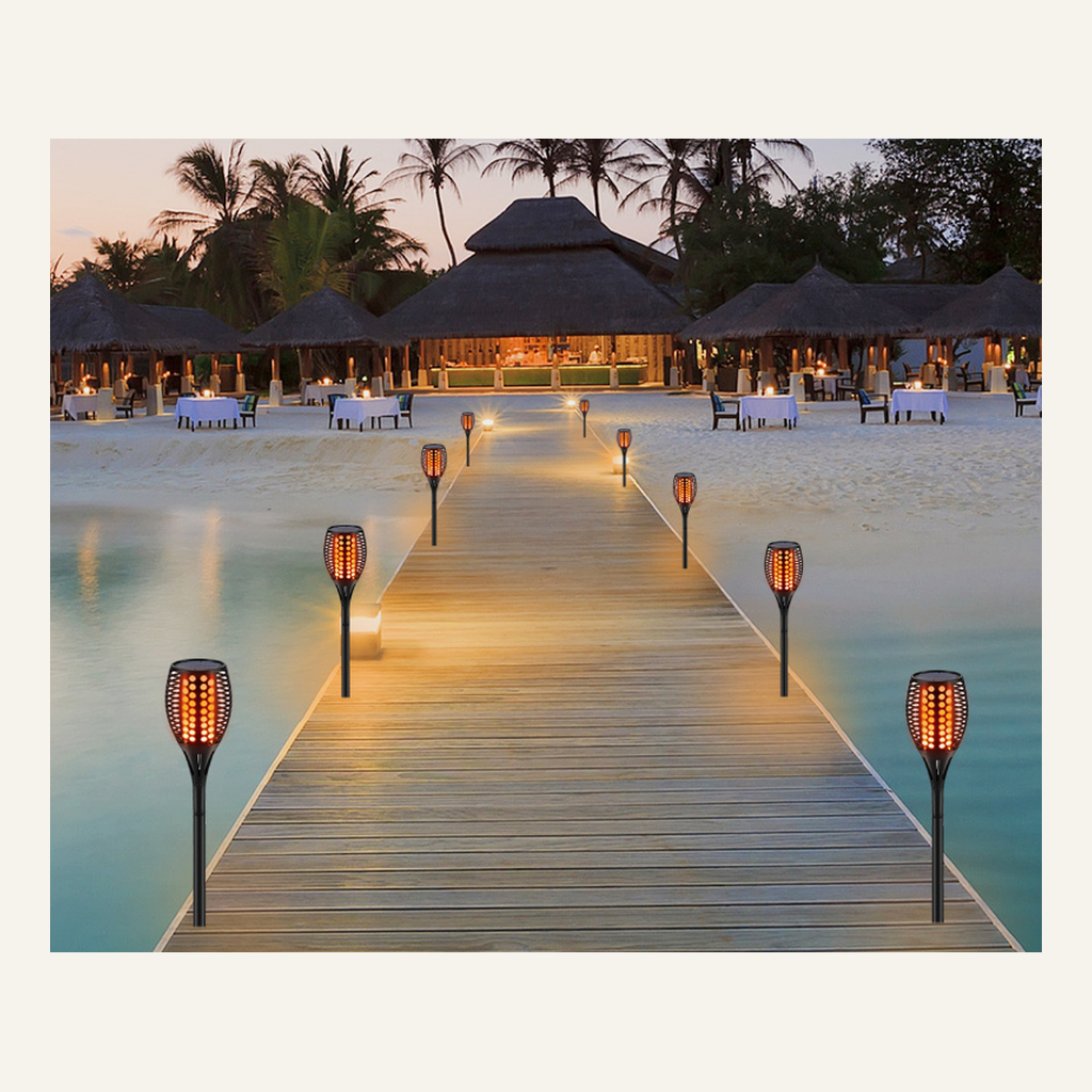 Solar flame-effect torches lining an outdoor boardwalk