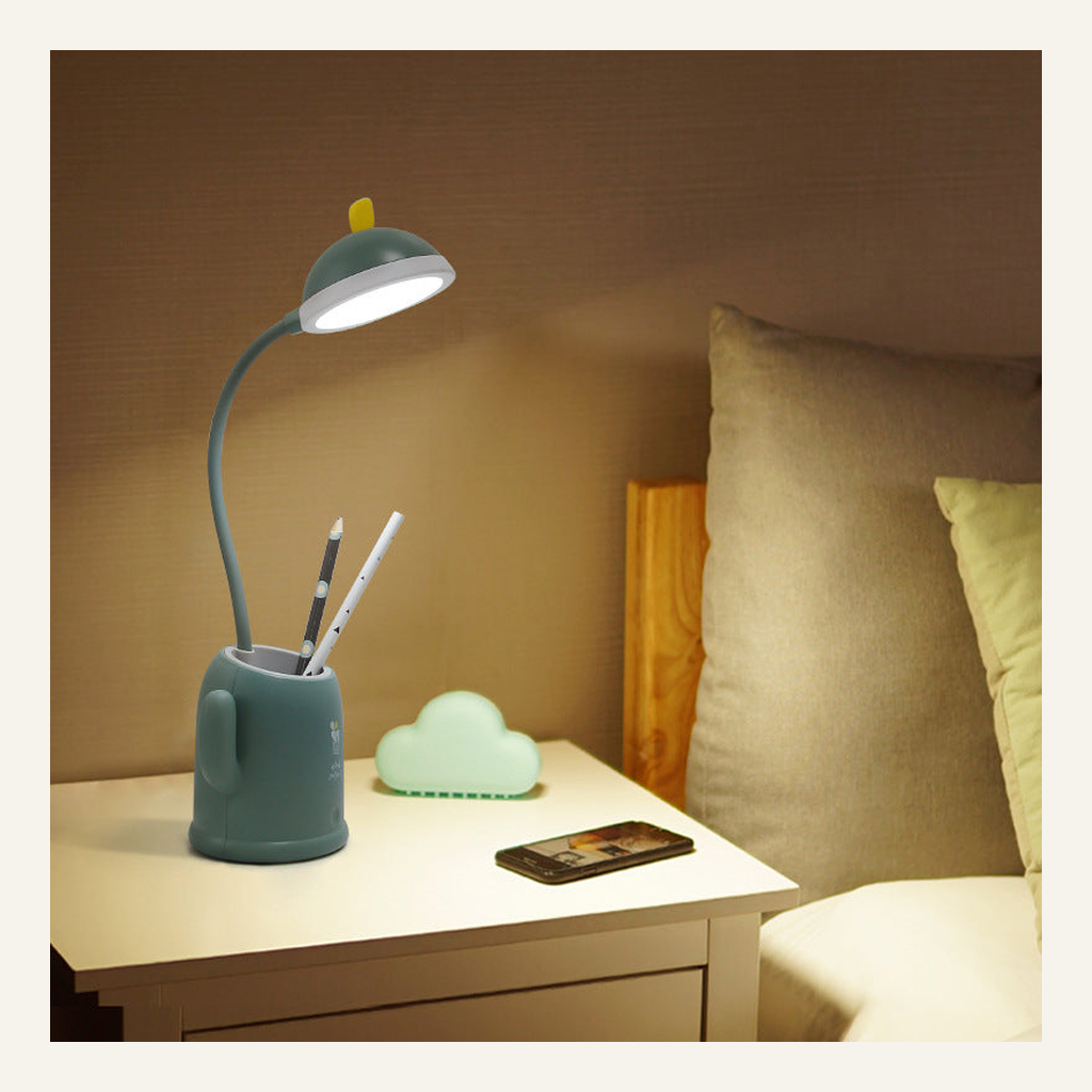 Green cactus desk lamp illuminated on a bedside table