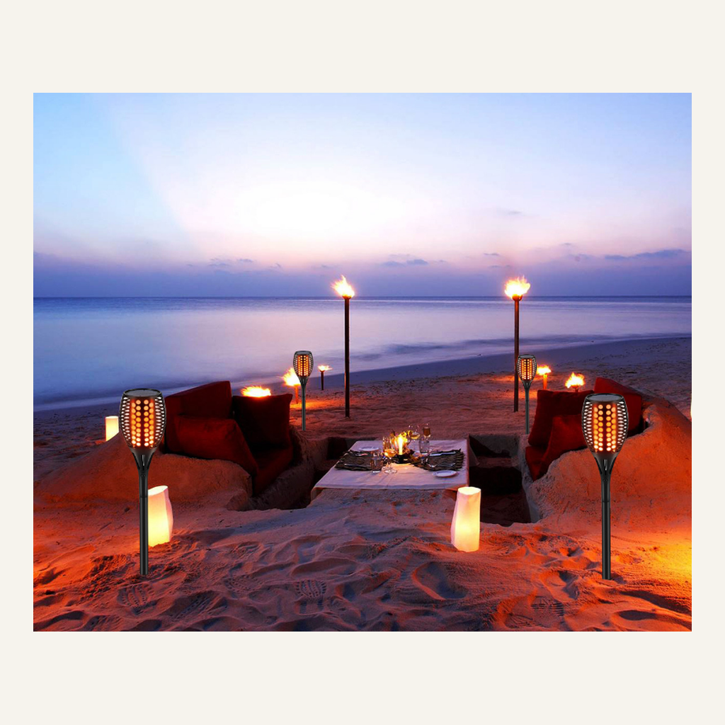 Solar flame-effect torches in a beach seating area