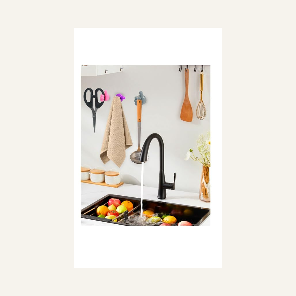 Thumb-shaped hooks holding kitchen items on a wall