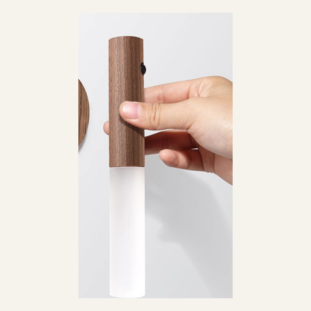 Walnut motion-sensor night light held in one hand