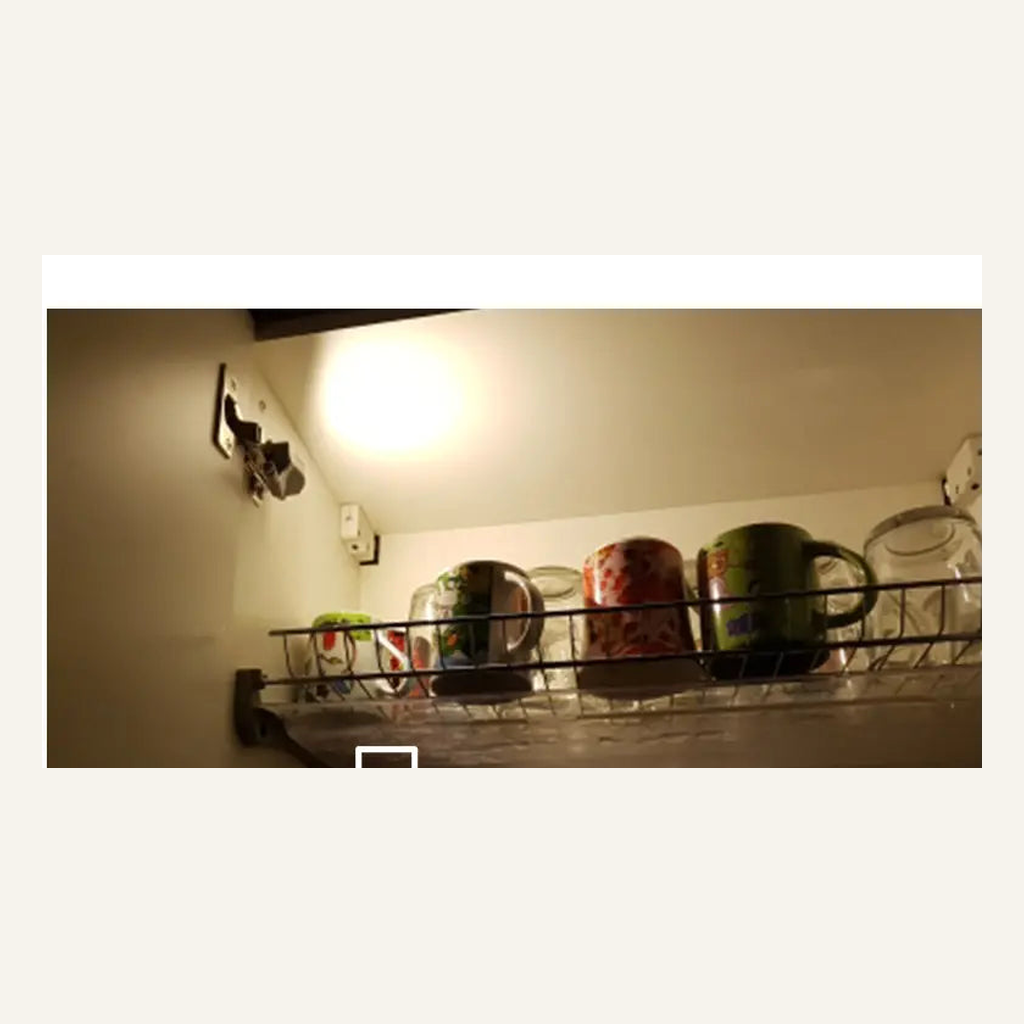 Cabinet hinge LED light illuminating a cupboard