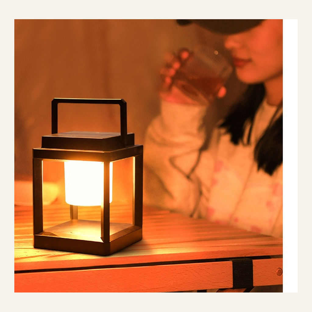 Black portable camping lantern in an evening table setting