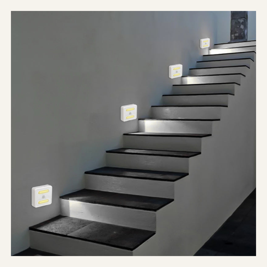 White motion-sensor cabinet lights installed beside stairs